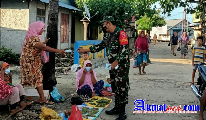 Babinsa Koramil 1509-05/Kayoa Bagikan Masker untuk Pedagang Pasar dan Sosialisasi Vaksinasi Masal